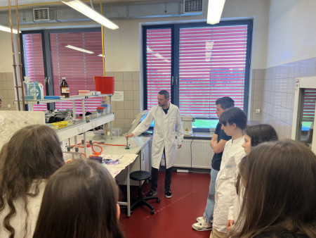 Nauczyciel w laboratorium z grupą uczniów.