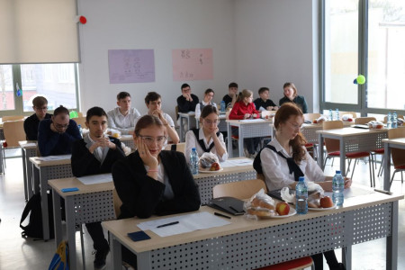 Uczniowie siedzą za stolikami