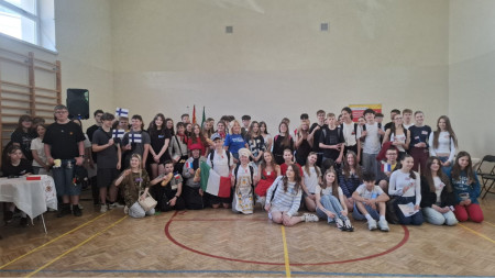 Grupowe zdjęcie uszestników Gry. Duża grupa uczniów i opiekunów pozuje do zdjęcia na sali gimnastycznej.
